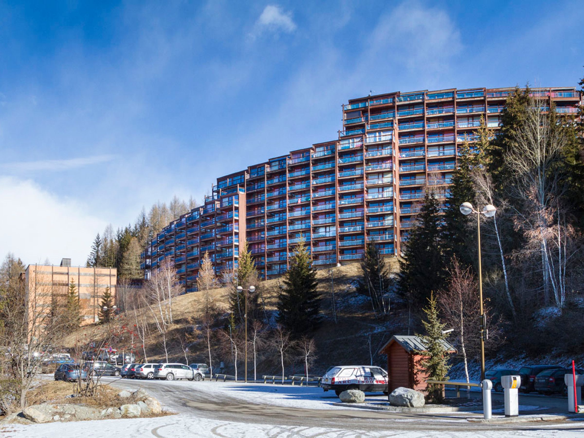 A multi-story hotel with a modern design, featuring balconies on each floor.