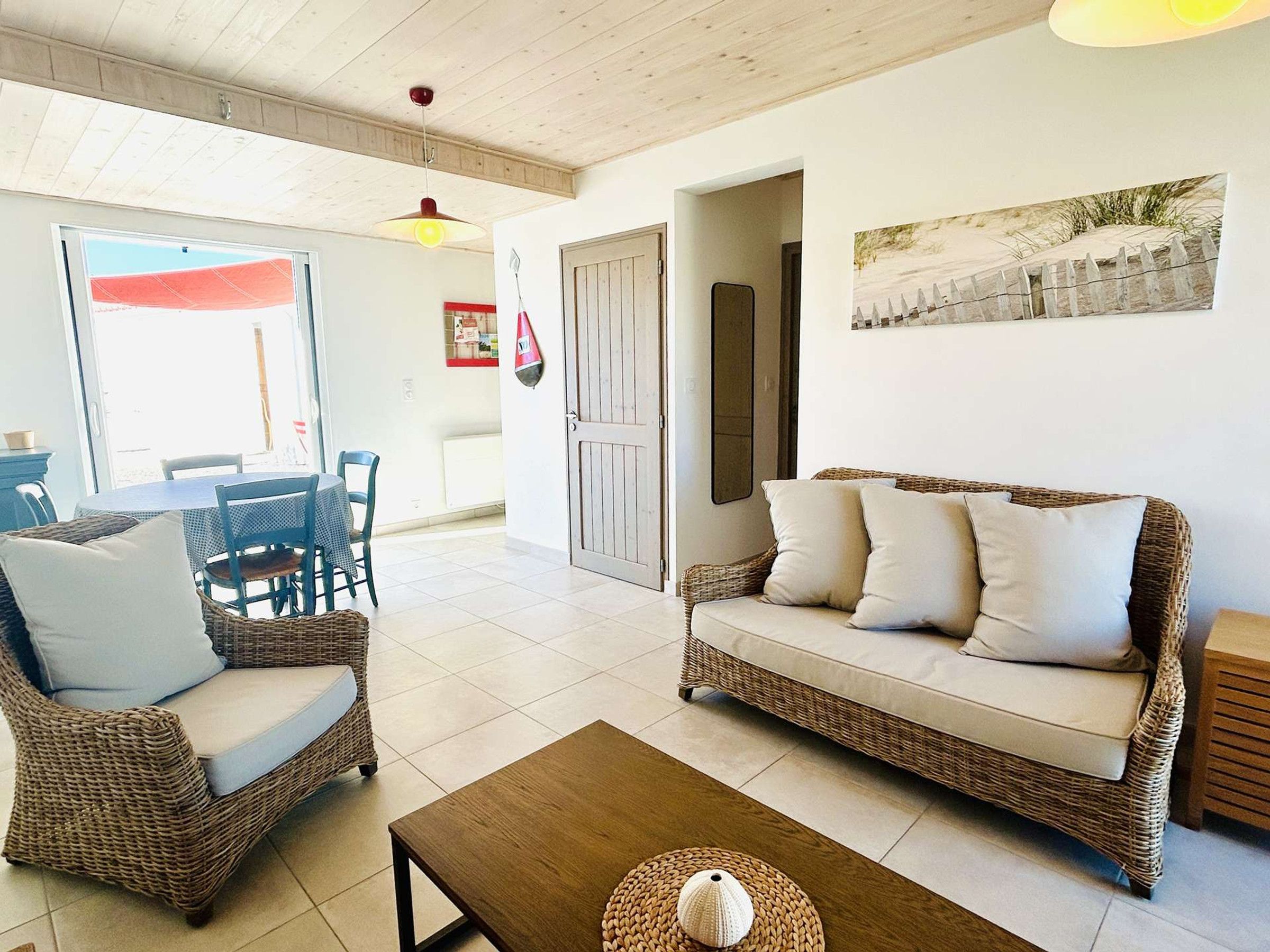 A furnished living room with a sofa, chairs, a coffee table, and a dining area with a table and chairs.
