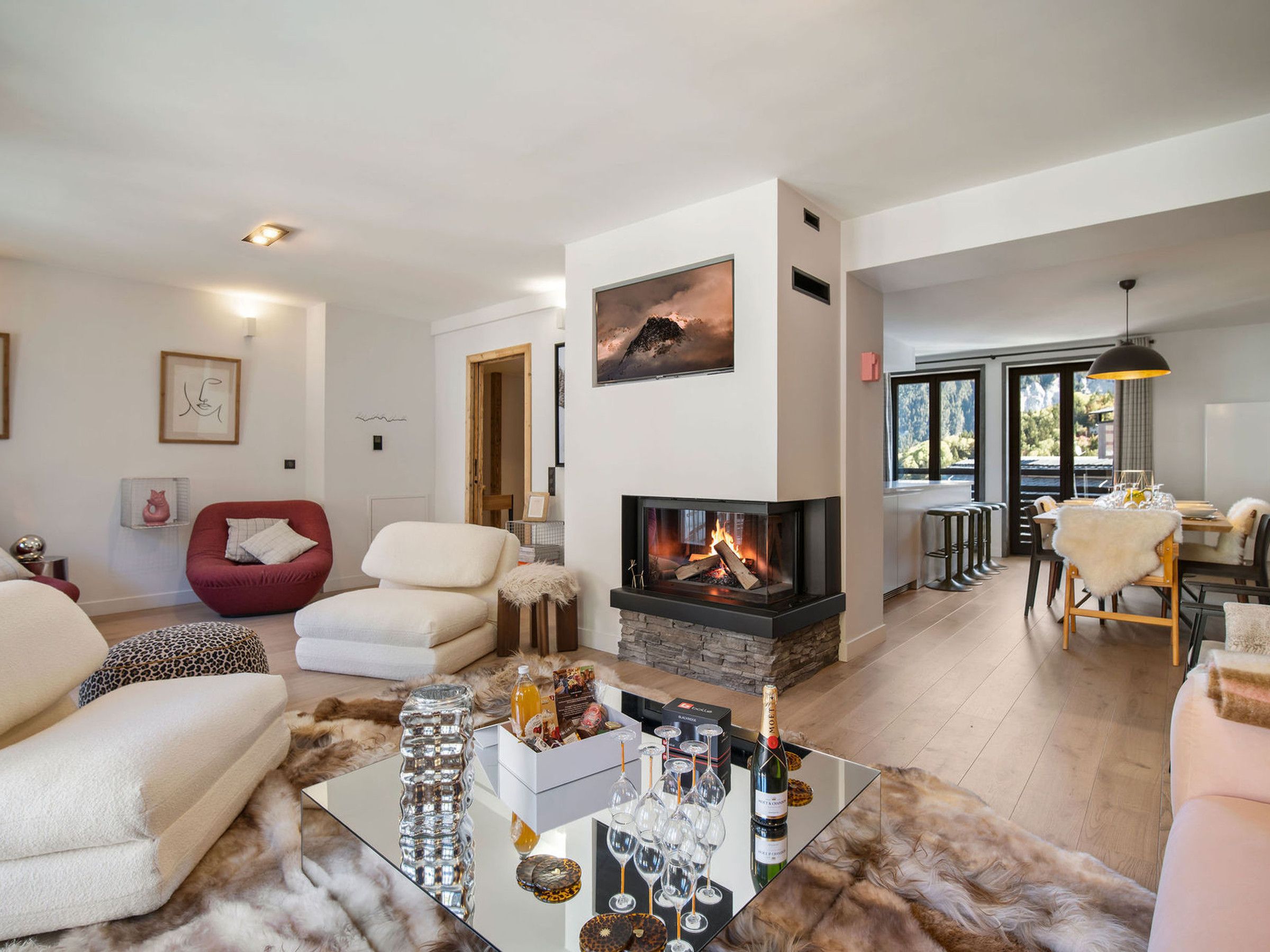 Una sala de estar moderna con chimenea, un comedor con vistas y una zona de estar acogedora.