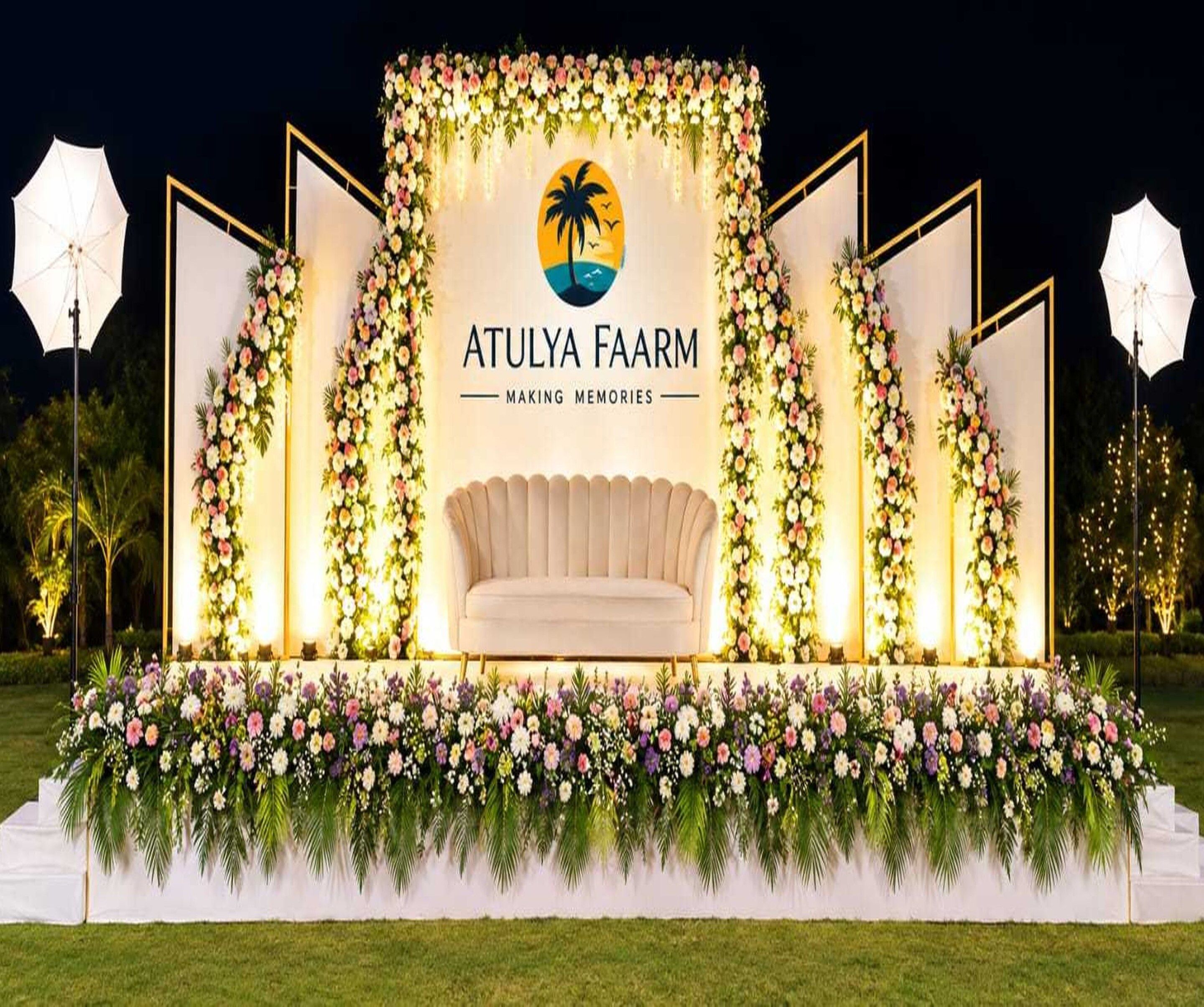 A stage with a logo, a sofa, and floral decorations.