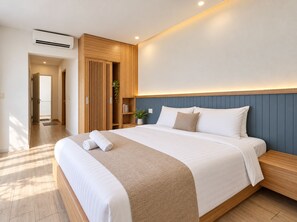 Ein modernes Hotelzimmer mit einem großen Bett, einem Holz-Kopfteil und einem eingebauten Kleiderschrank.