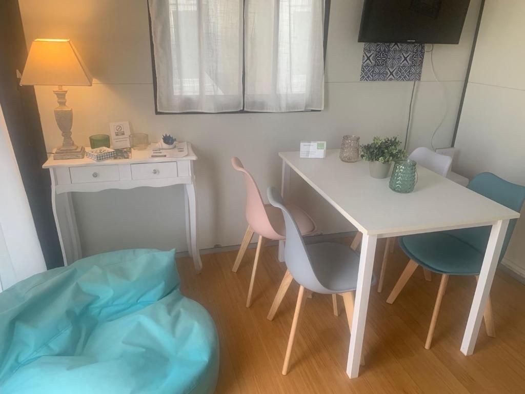 Ein Zimmer mit Schreibtisch, Stuhl, Sitzsack, Fernseher und einem Fenster mit Vorhängen.
