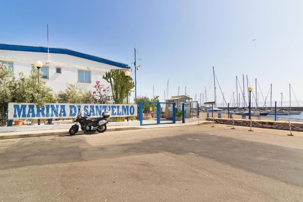 A marina with a sign reading 'MARINA DI SAN'TELMO' and a motorcycle parked in front.