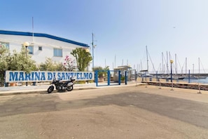 A marina with a sign reading 'MARINA DI SAN'TELMO' and a motorcycle parked in front.