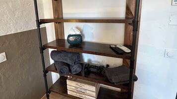 A wooden shelf unit with multiple shelves, a radio, and a box labeled 'HIGH QUALITY THE HOME SERVICE COLLECTION.'