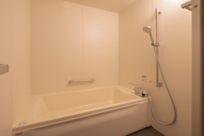 A standard hotel bathroom with a bathtub, a shower, and a toilet. - BITO DISCONT HOTEL LDx (Tsuyama)