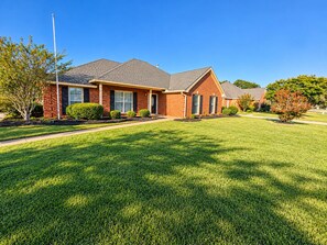 A residential house with a well-maintained lawn, a clear sky, and a flagpole. - Cozy, Clean, Home with lots of things to do, Great for Short or Long term stays (Montgomery)