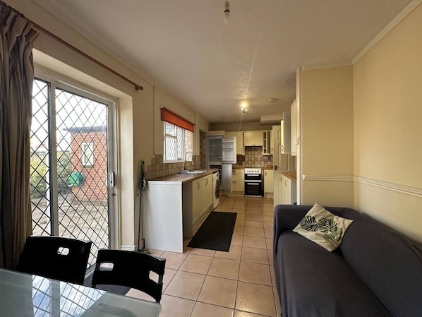 A compact living space with a kitchenette, a dining area, and a sofa. - 4 bedroom House in Guildford! (Surrey)