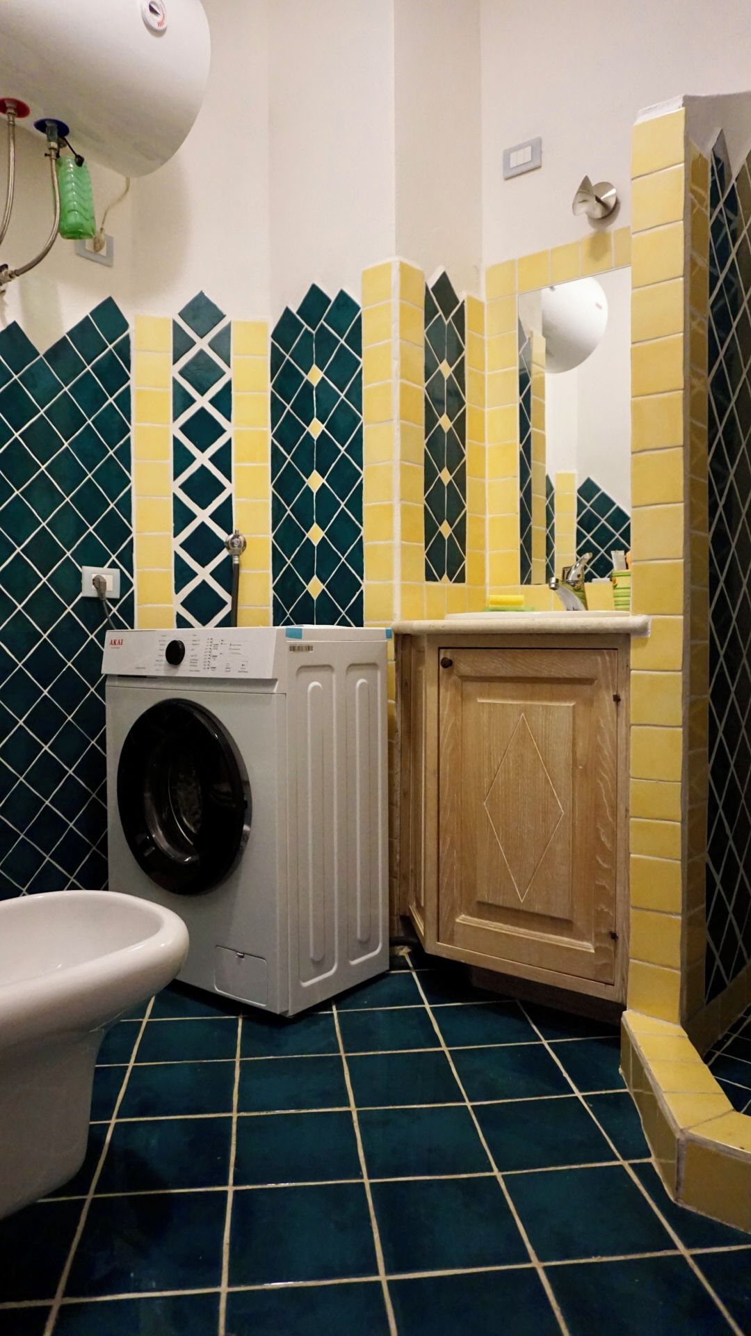 A compact bathroom with a washing machine, a toilet, and a sink.