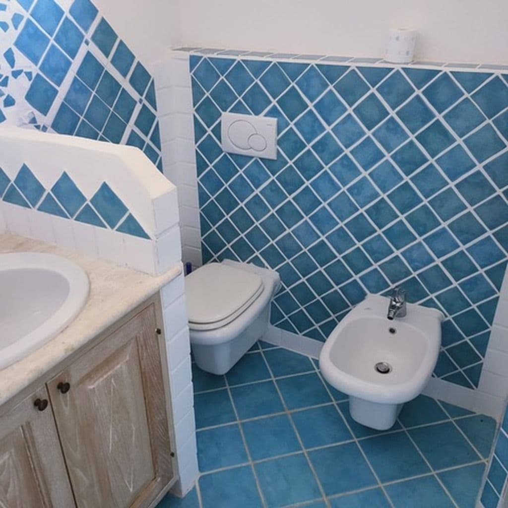 A bathroom with a sink, toilet, and bidet.