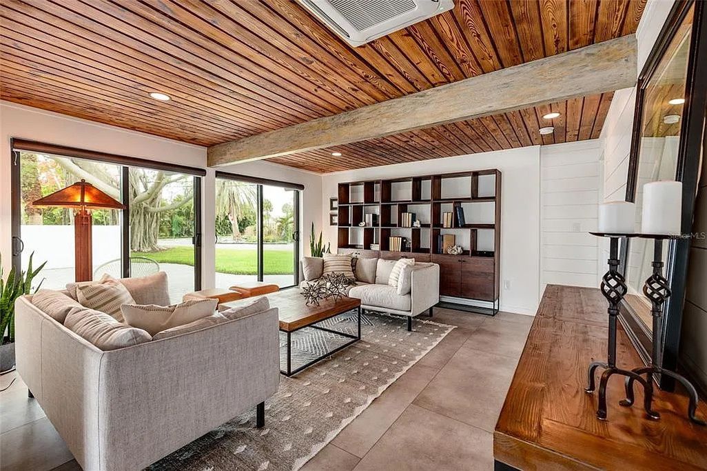 A modern living room with a sofa, coffee table, and bookshelves.