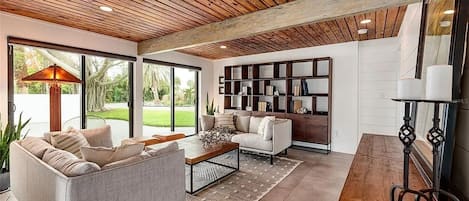 A modern living room with a sofa, coffee table, and bookshelves.