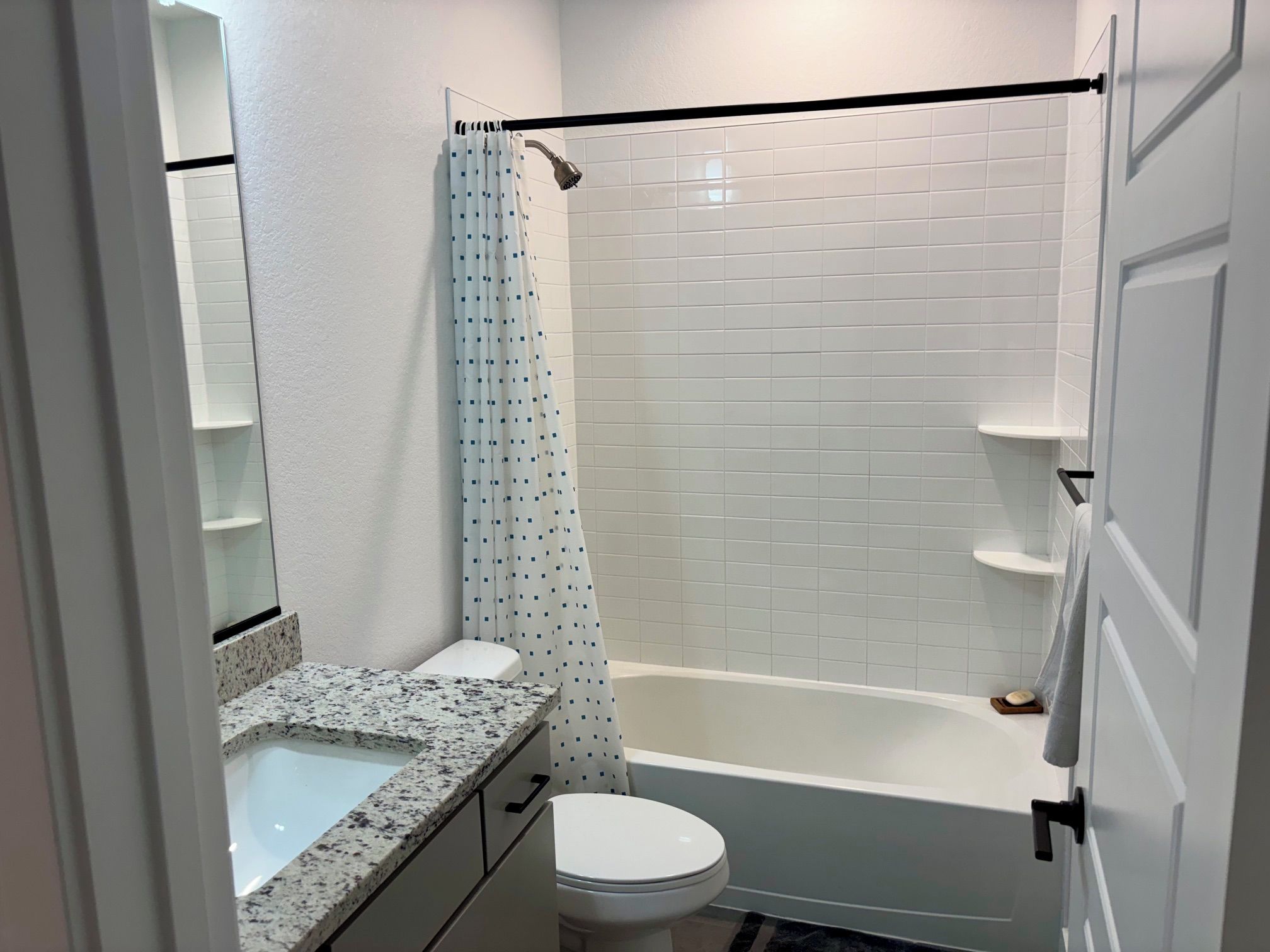 Une salle de bain avec douche, toilettes et lavabo.