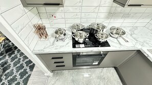 Une cuisine avec un dosseret en marbre, une cuisinière à gaz et un four encastré.