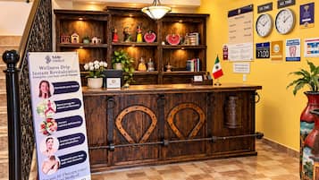 A reception desk with a wooden design, a signboard advertising IV therapy, and a wall clock.