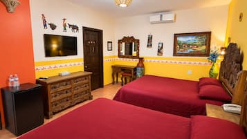 A hotel room with two beds, a TV, a dresser, and a desk with a chair.