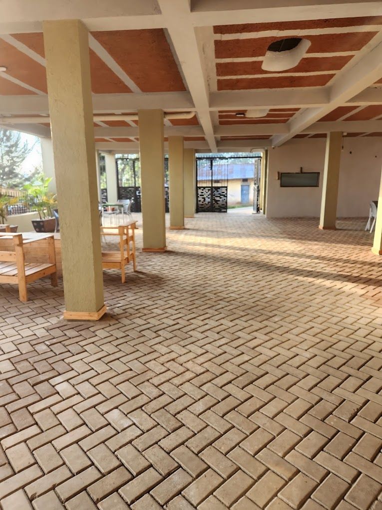 A spacious indoor area with a brick floor and wooden furniture.