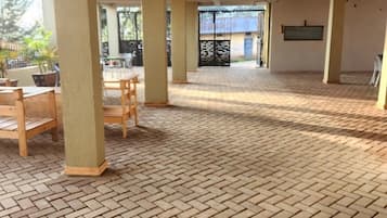 A spacious indoor area with a brick floor and wooden furniture.