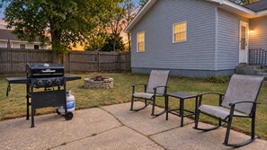 A backyard with a barbecue grill, a gas tank, and two rocking chairs. - Comfortable Home Base | Near ND, IUSB & Hospitals (Mishawaka)