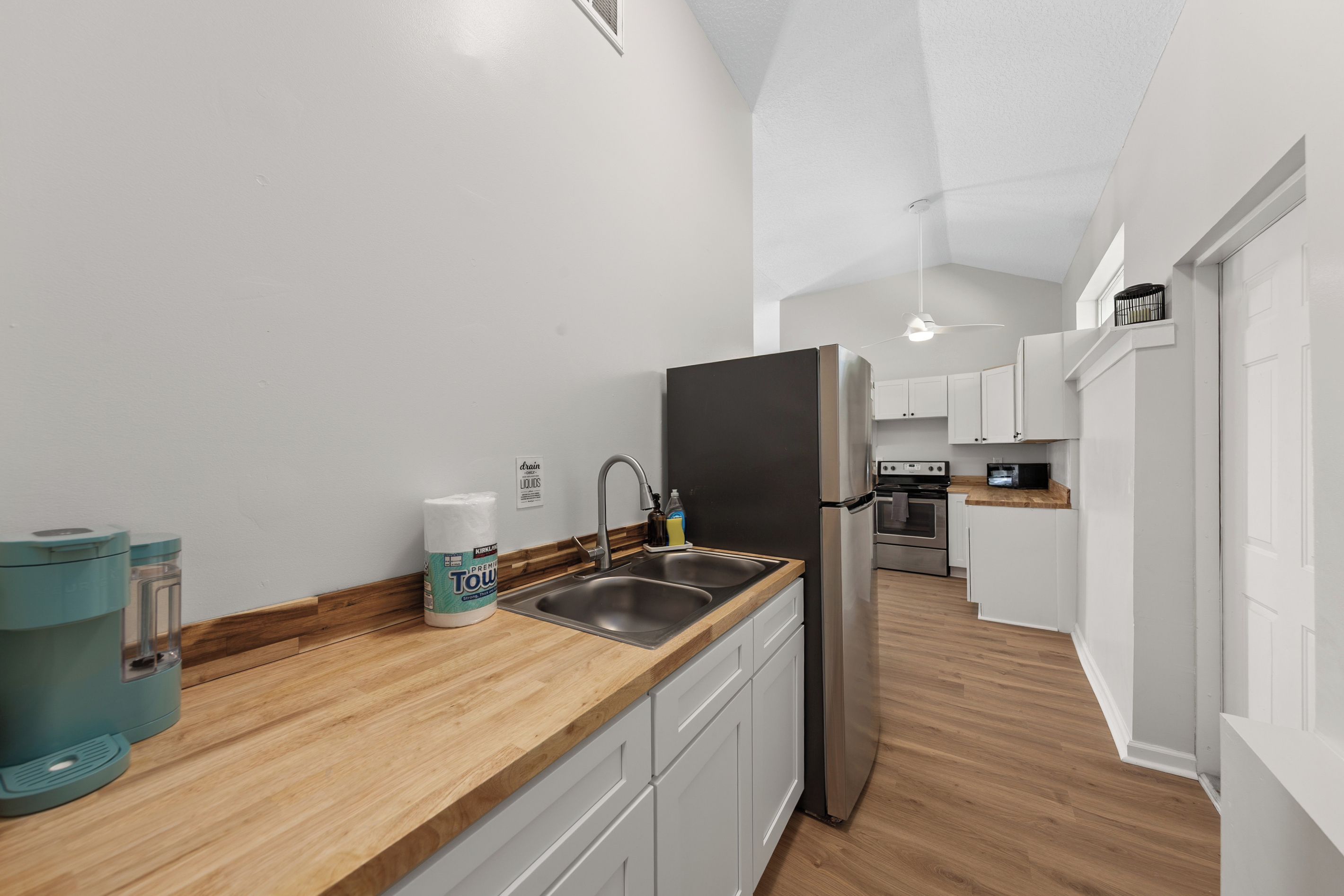 Eine moderne Küche mit einem Edelstahl-Kühlschrank, einer Spüle und Holzarbeitsplatten.