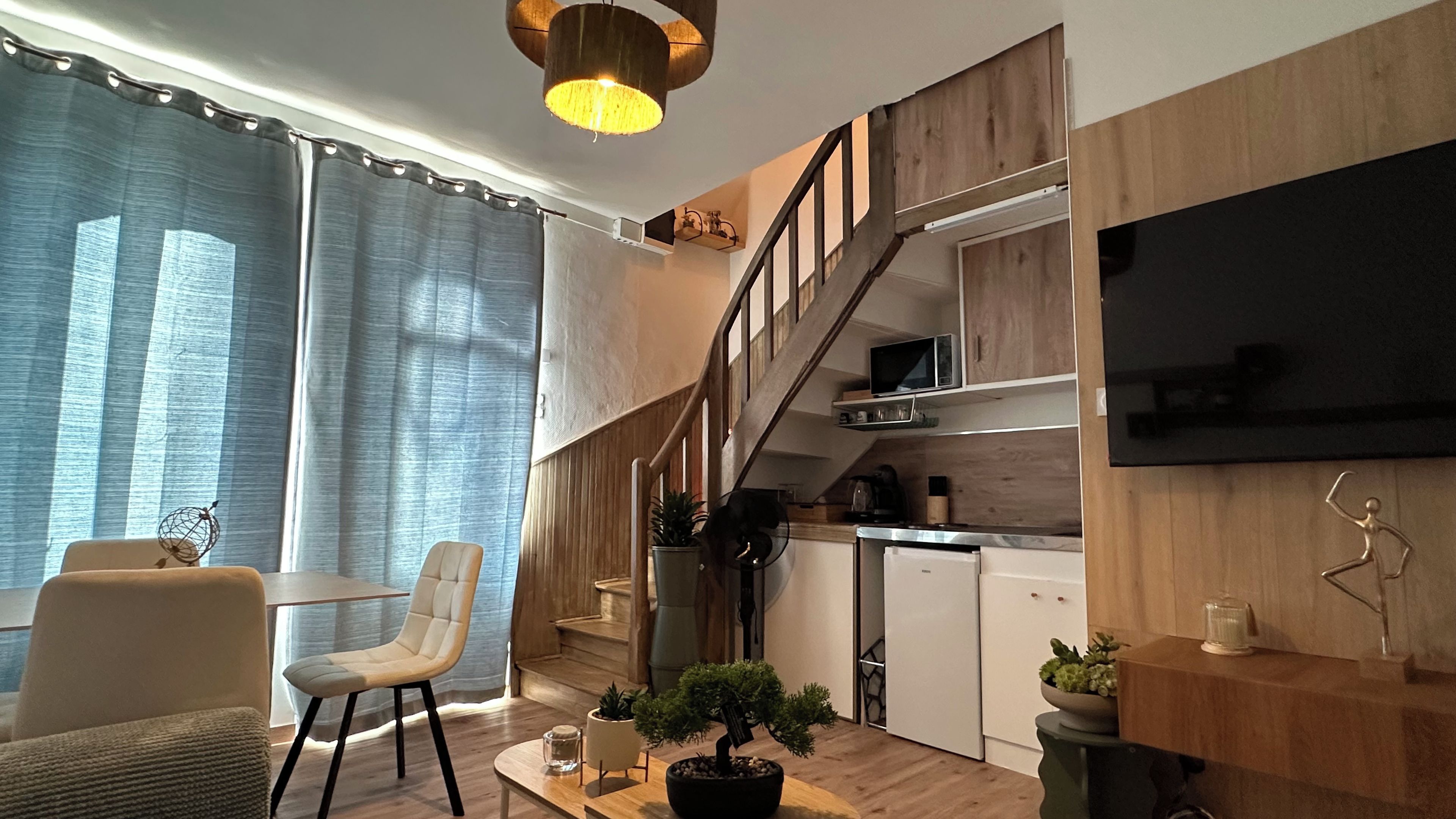 Un espace de vie moderne comprenant un escalier, un coin repas et une cuisine.
