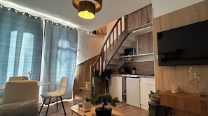 Ein moderner Wohnraum mit Treppe, Essbereich und Küche.