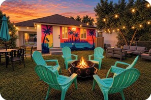 A house with a fire pit, outdoor seating, and a mural on the exterior wall. - Private hot tub. Miami can wait. (Miami)