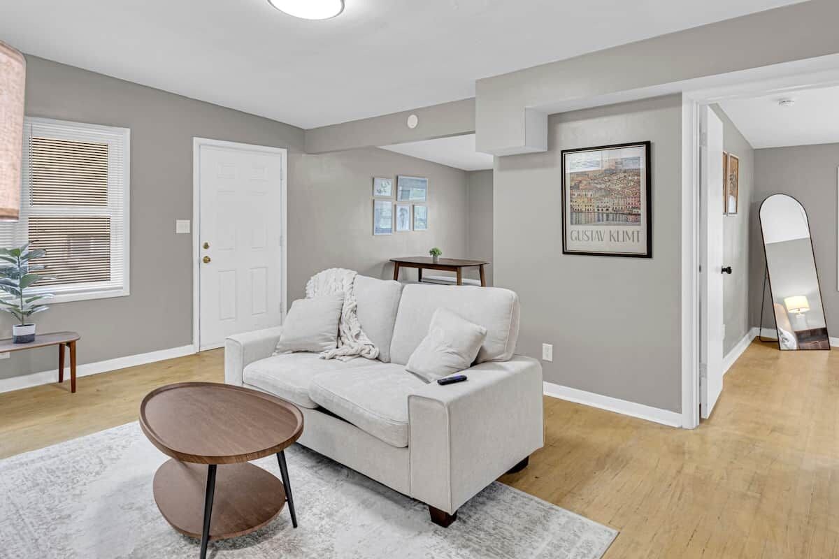 A living room with a sofa, a coffee table, and a framed picture on the wall.