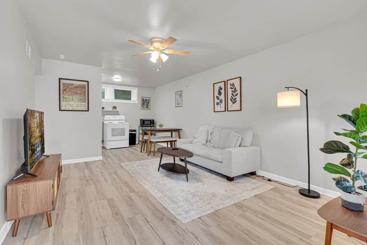 A modern living room with a sofa, coffee table, and a TV on a wooden cabinet.