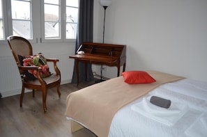 A room with a bed, a chair with a cushion, a desk with a keyboard, and a lamp. - Hotel und Gasthaus Löwen im Hotzenwald (Murg)