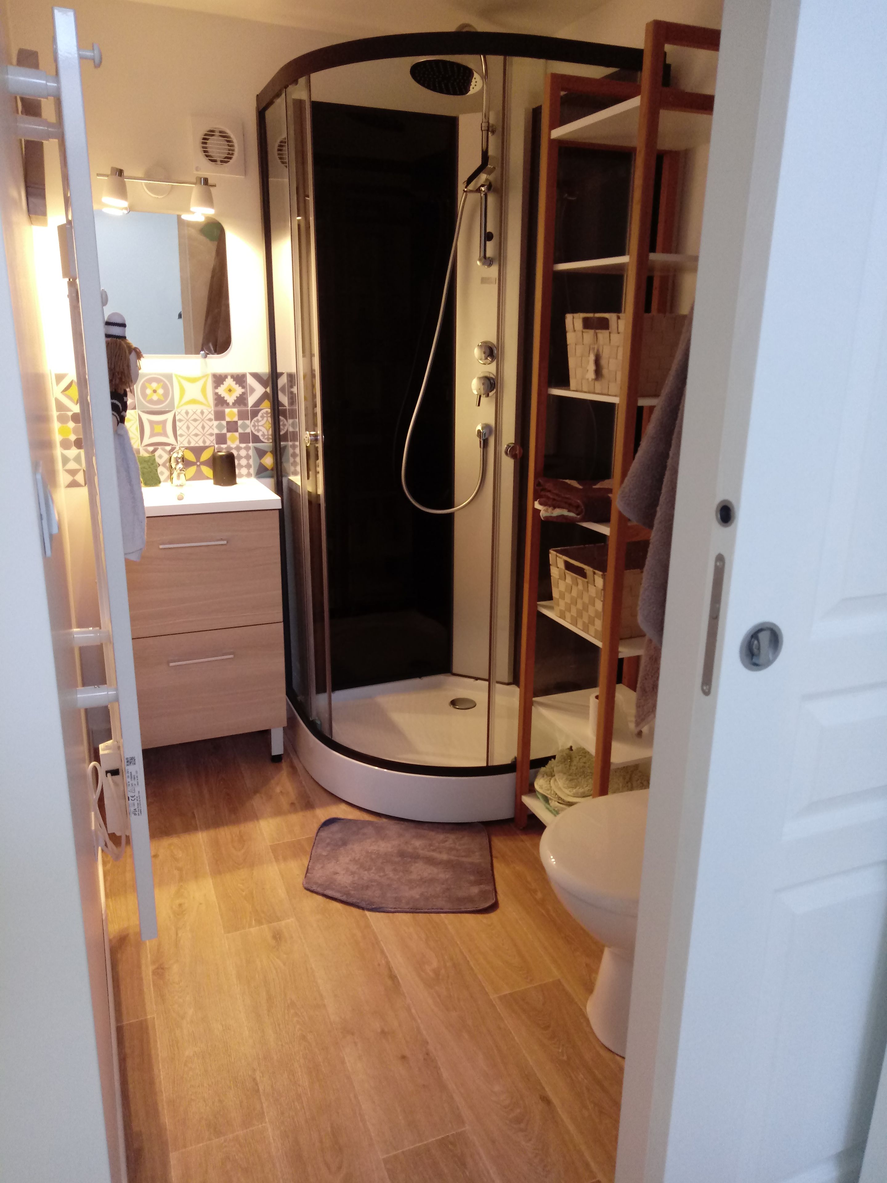 Une petite salle de bain comprenant un espace douche, un lavabo et des toilettes.