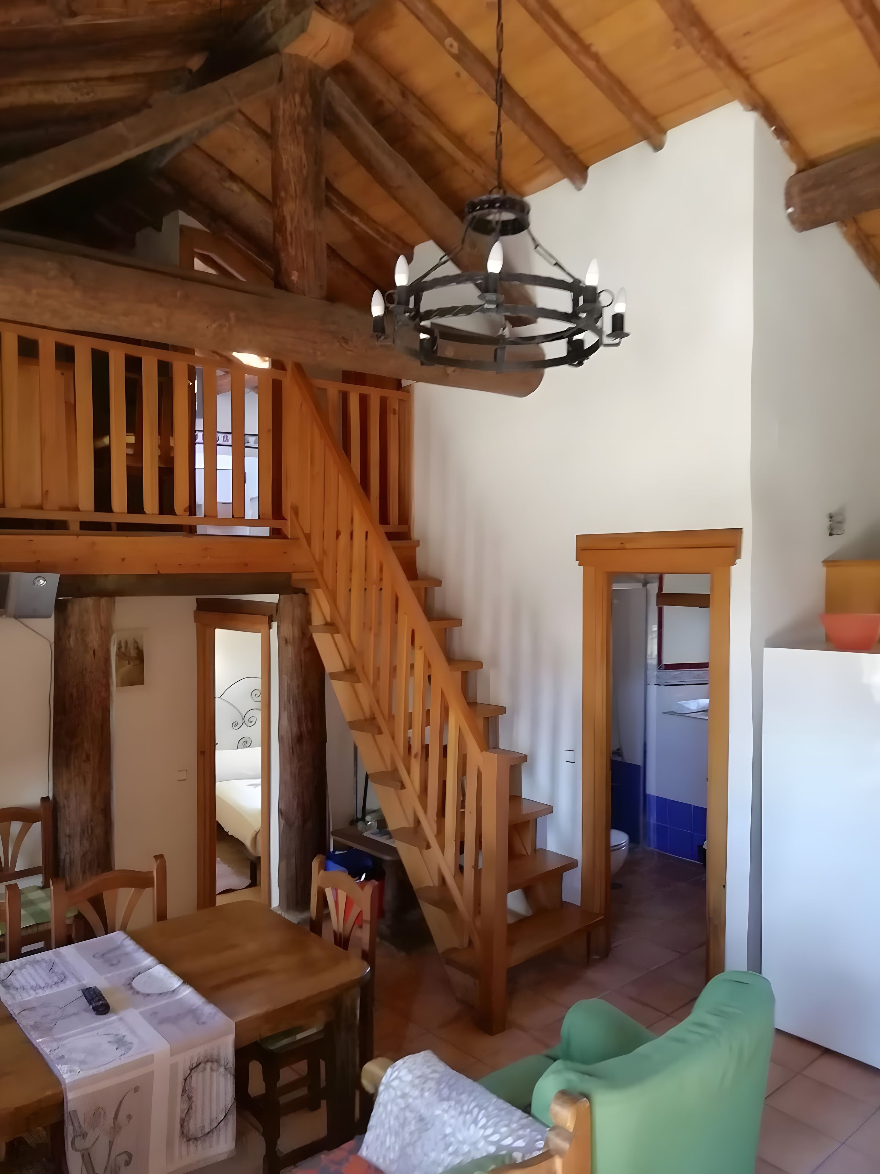 A wooden interior with a staircase, a dining area, and a kitchen.