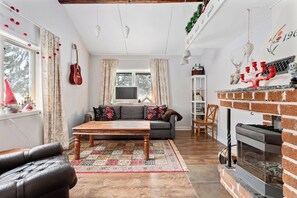 Un salon avec une cheminée, un canapé, un téléviseur et une table basse.