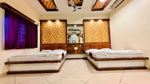 Habitación de hotel con dos camas, cabecero de madera, piso de baldosas y ventana con cortinas.