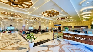 A hotel lobby with a reception desk, seating areas, and a decorative ceiling. - Maa Vaishnavi New Restaurant & Hotel (Omkareshwar)
