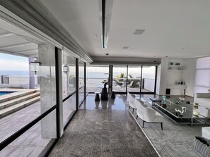A modern interior with a pool, seating area, and a view of the ocean. - New Listing (Rio de Janeiro)