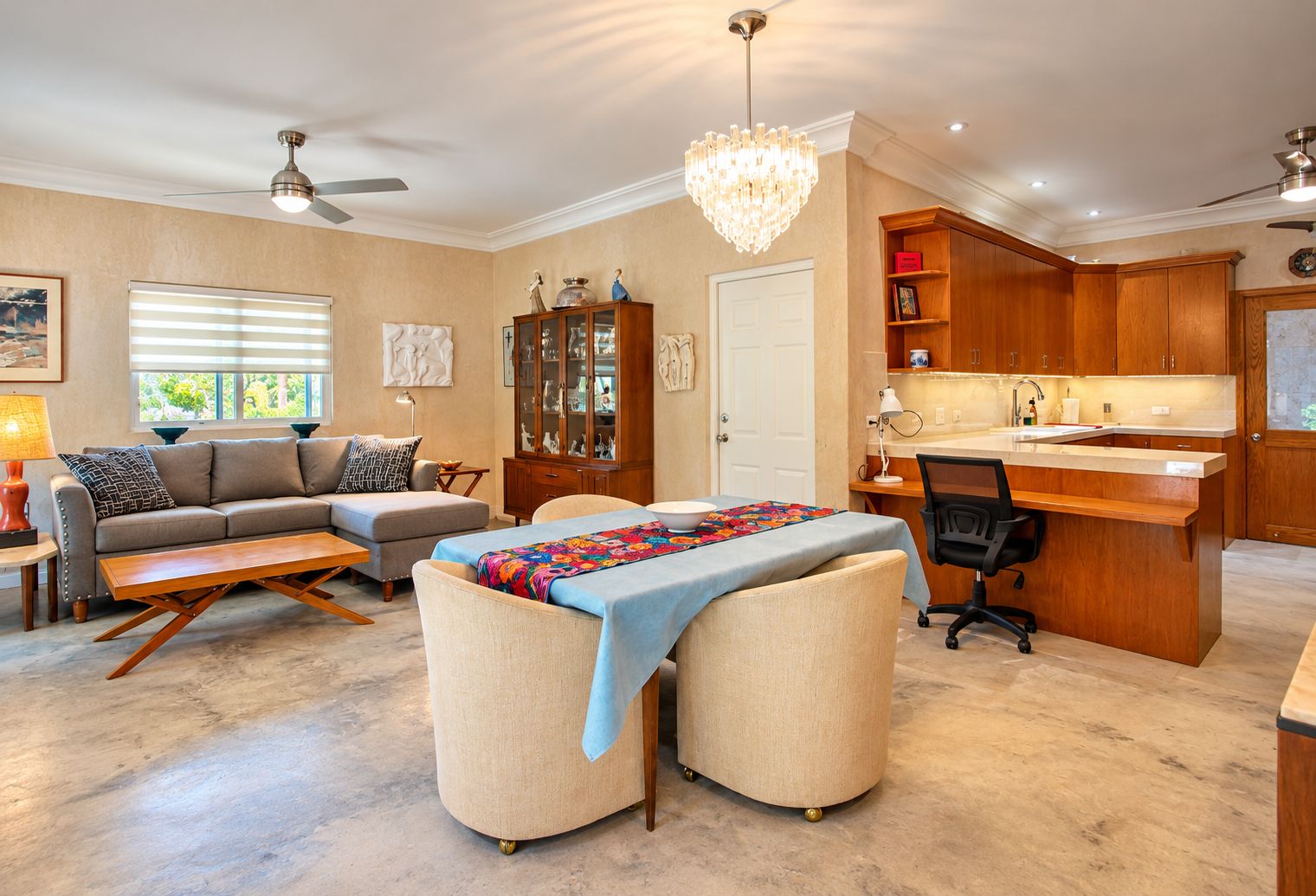 Un salon spacieux comprenant un canapé, un pouf et un coin repas avec une table et des chaises.