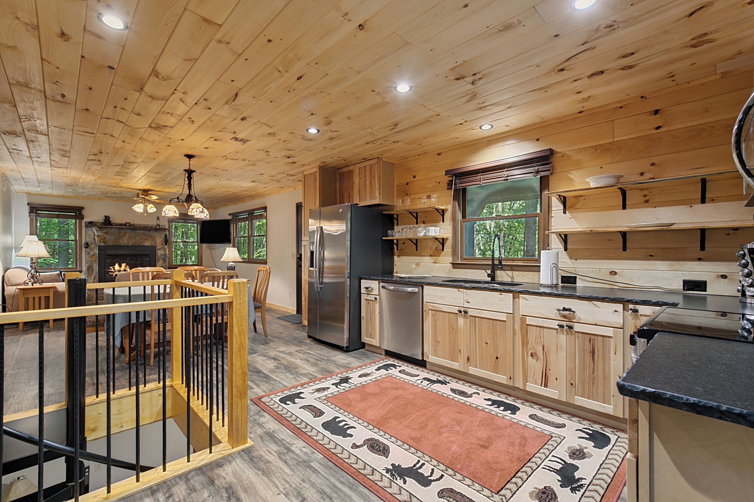 A wooden interior with a kitchen, dining area, and a fireplace.