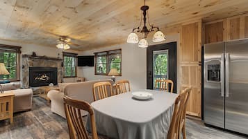 Ein gemütliches Blockhaushaus-Interieur mit Essbereich, Kamin und moderner Küche.