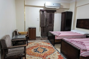 A small room with a bed, a sofa, a desk, and a wardrobe. - El Eman Hotel (Ar Radiseyah Bahri Edfu)