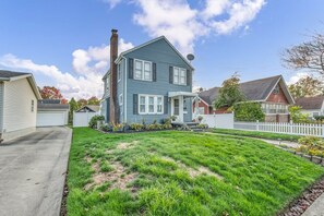 A two-story house with a front yard and a white picket fence. - Spacious Akron Retreat: 2 King Beds, Sunroom & Sleeps 12 (Akron)