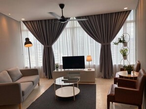 Una sala de estar moderna con sofá, mesa de centro y mueble para televisión.