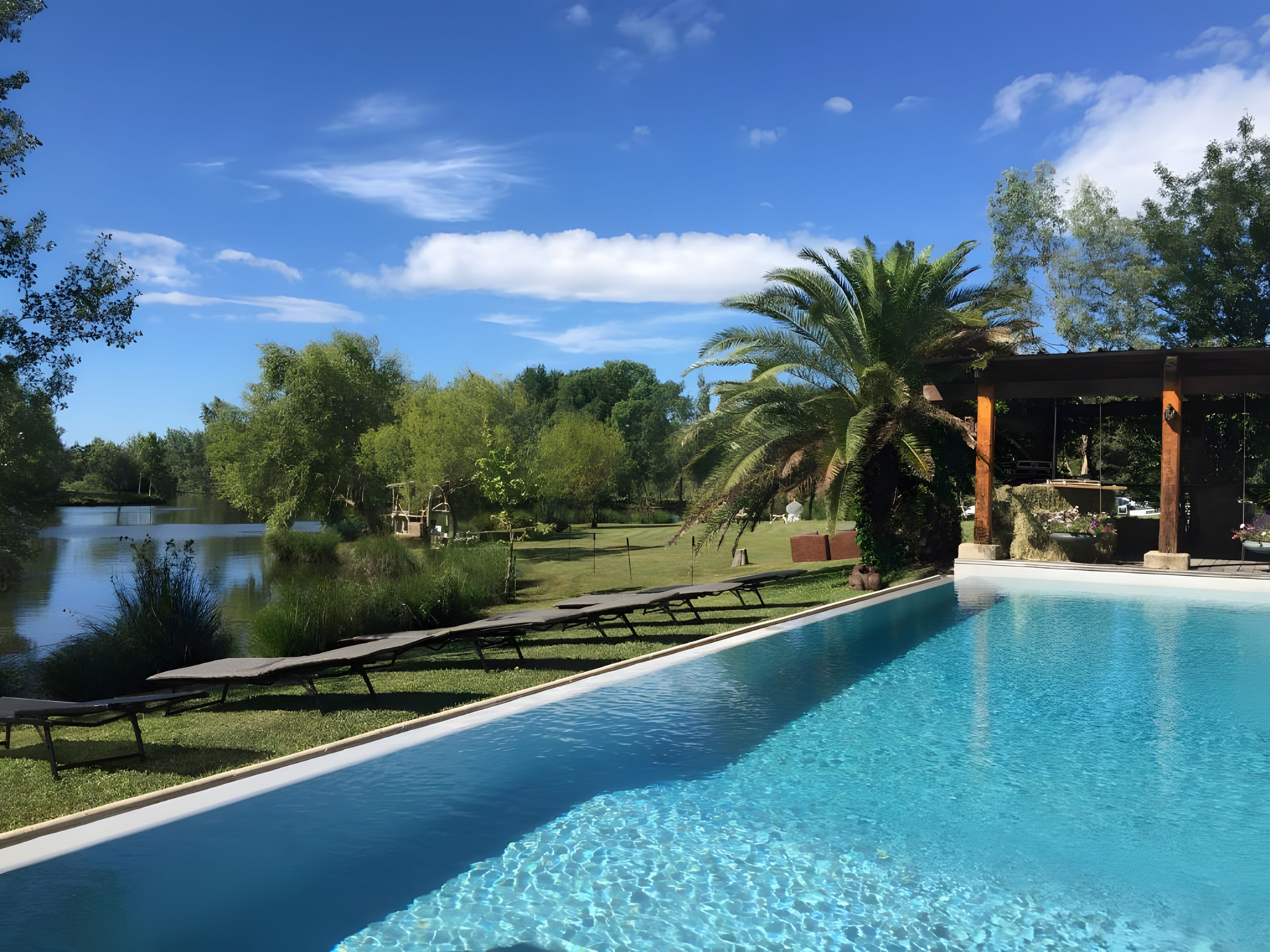 A swimming pool with a view of a lake and trees.