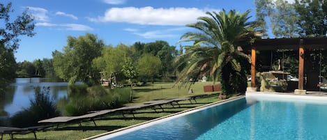 A swimming pool with a view of a lake and trees.