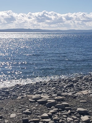 Un rivage rocheux, une mer calme et un ciel dégagé.
