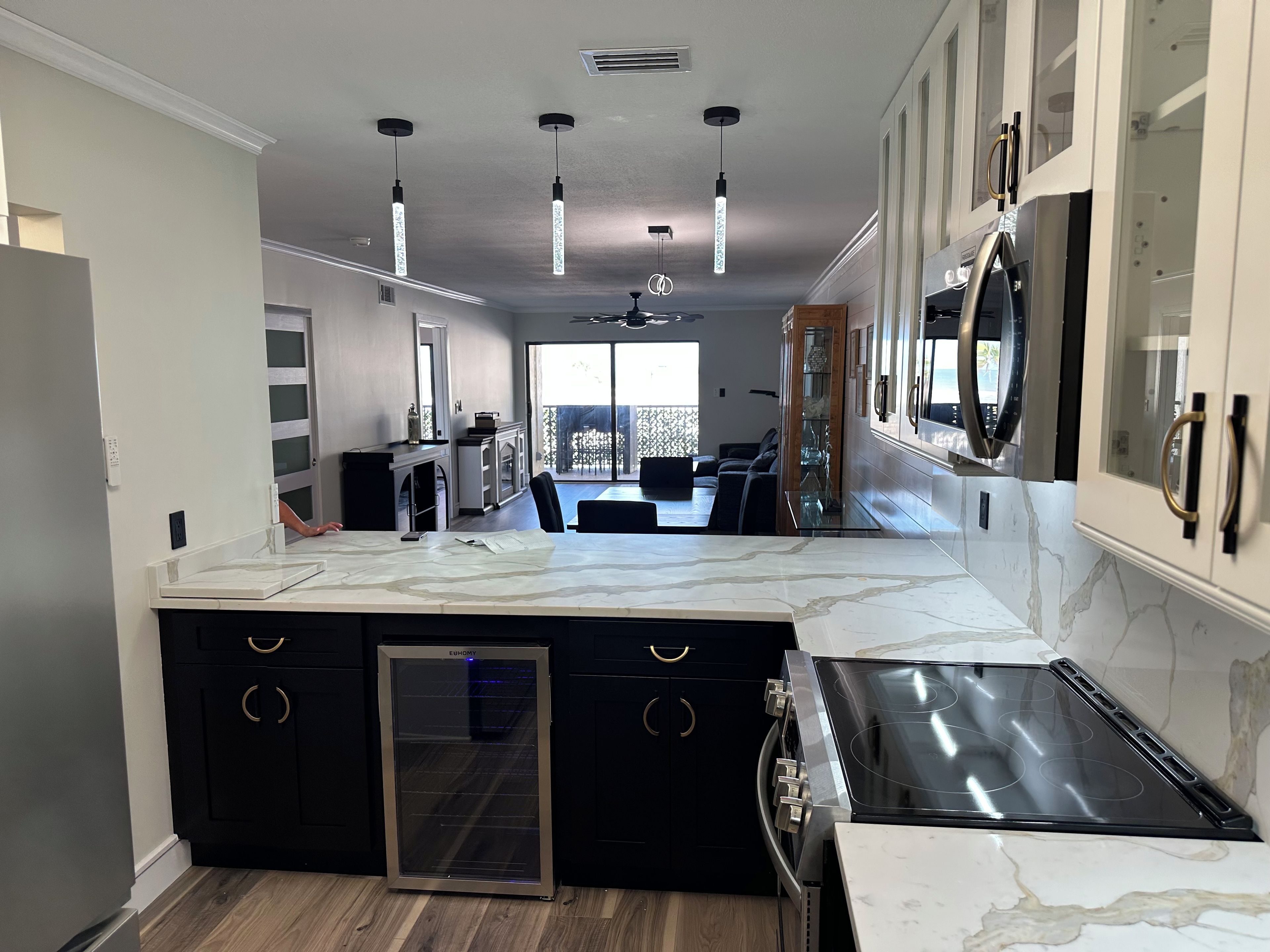 A modern kitchen with a central island, built-in appliances, and pendant lighting.