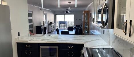 A modern kitchen with a central island, built-in appliances, and pendant lighting.