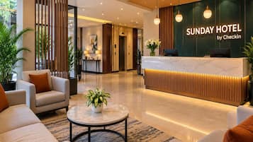 Uma área de recepção de hotel com design moderno, incluindo um balcão de atendimento, espaço para sentar e vista para o corredor.