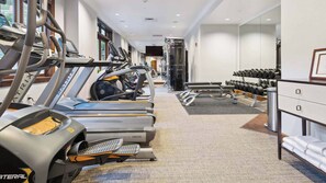 Ett gym med löpband, träningsbänkar och hantlar.