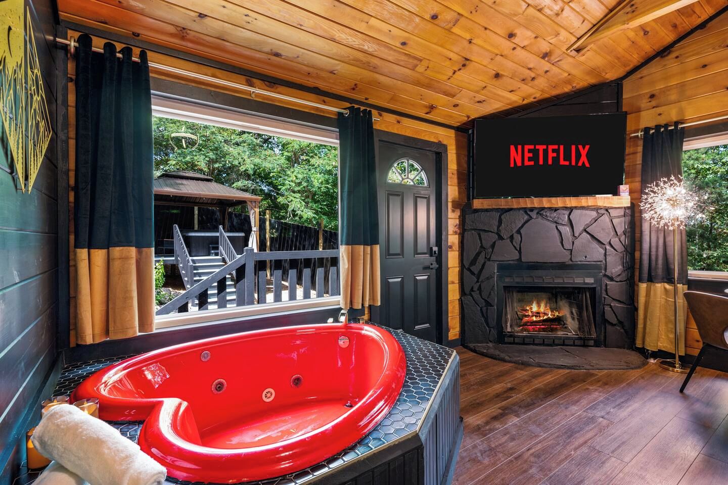 Une pièce avec une cheminée, une grande fenêtre et un écran affichant le logo de Netflix.